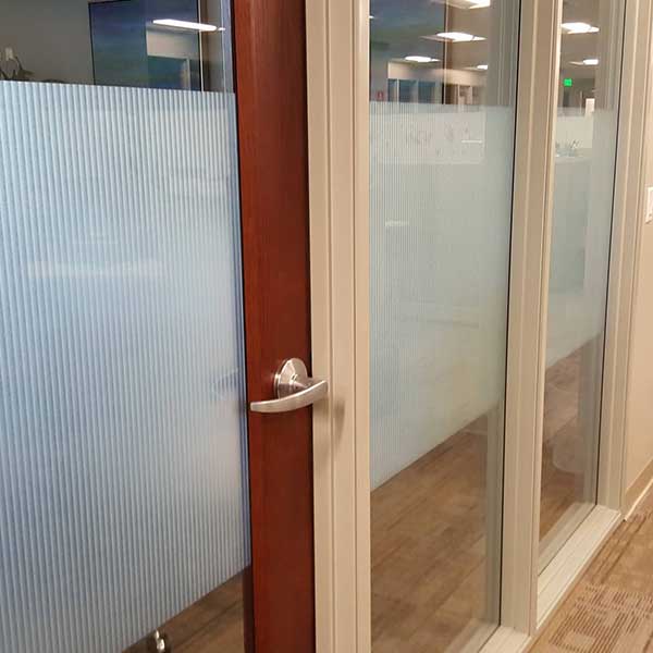 3M Fasara decorative privacy film with fine linear texture applied to office glass partitions and a door