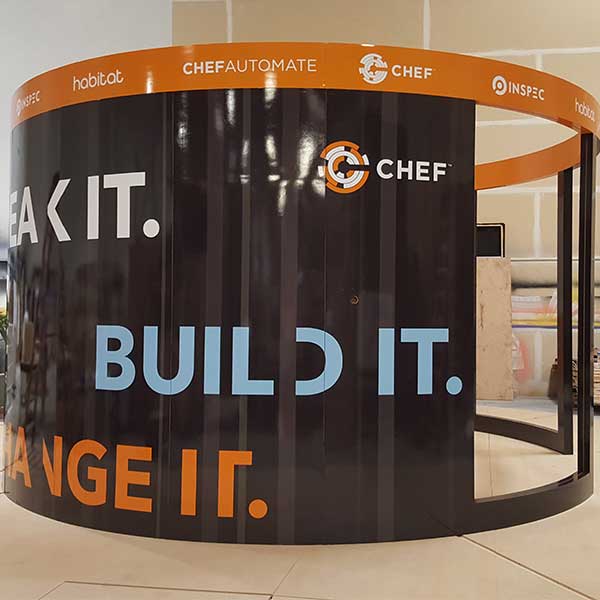 Curved trade show booth wrapped in Chef branded graphics reading Build It