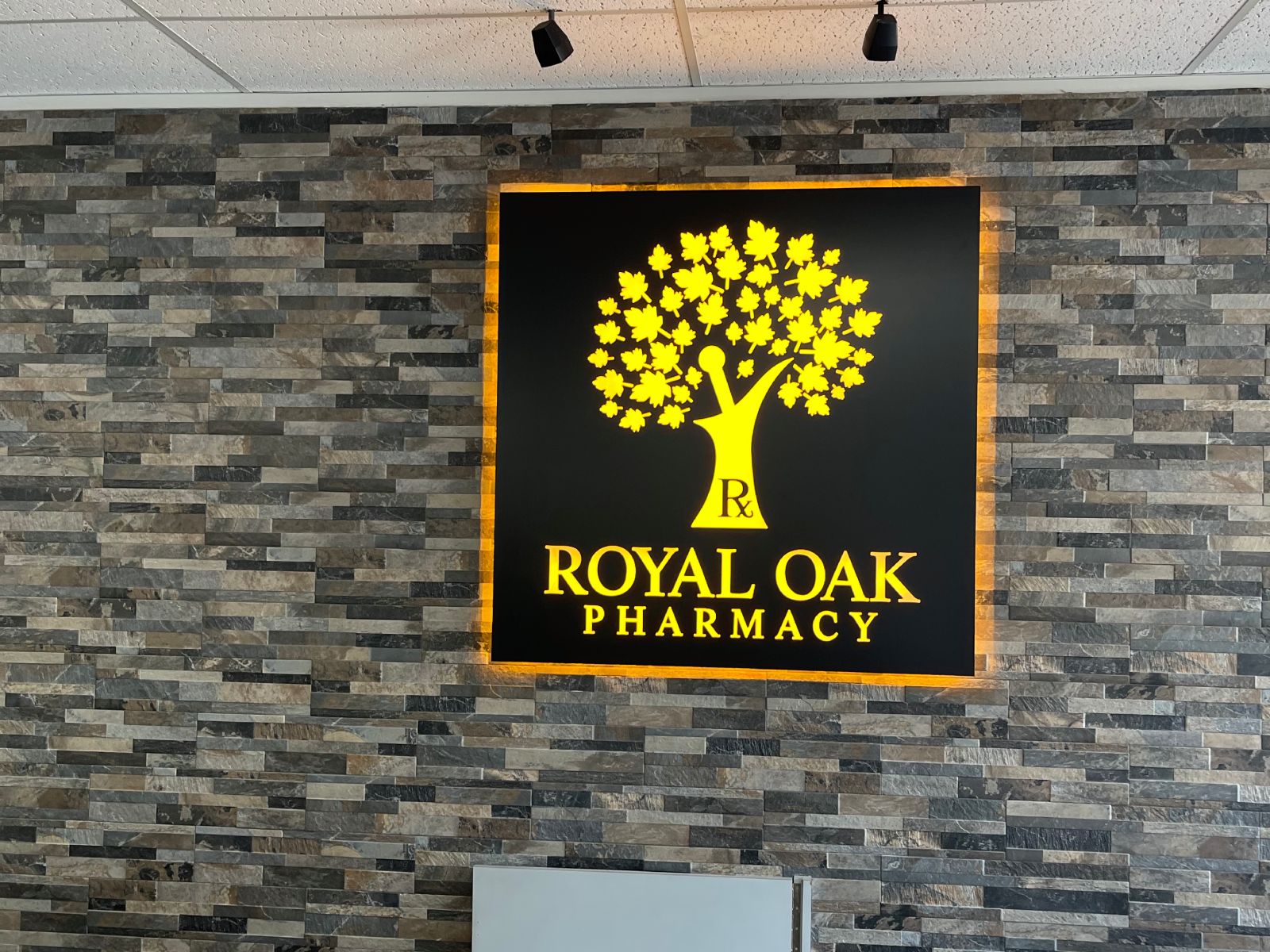 Illuminated backlit exterior sign for Royal Oak Pharmacy installed on a storefront facade