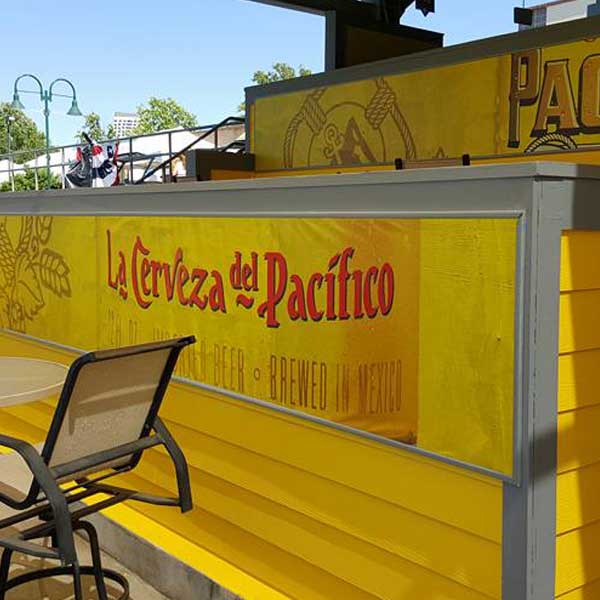 Yellow La Cerveza del Pacifico printed patio bar signage installed outdoors