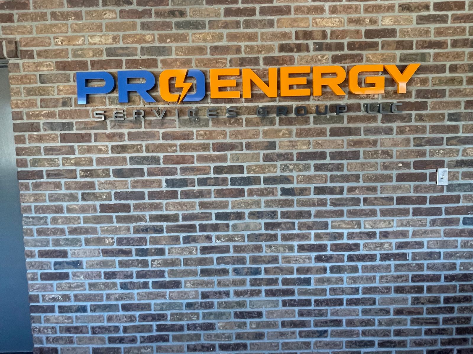 Dimensional metal letters mounted on an exterior office wall for ProEnergy Services Group